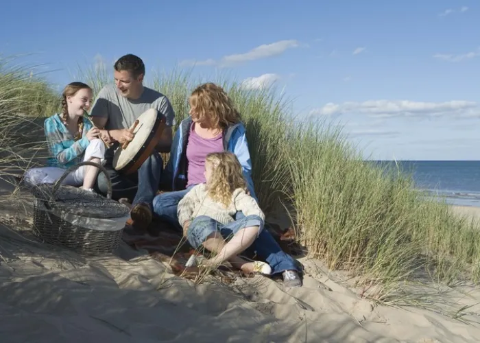 Family playing musical instruments at beach, Brittas Bay, Ireland
