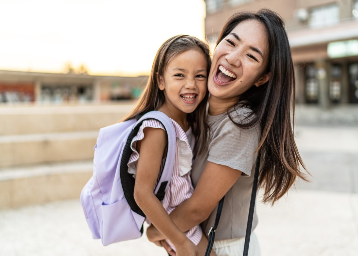 mom hugging her young girl after she goes back to school.