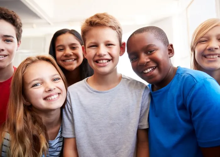 Portrait Of Smiling Male And Female Students In Grade School Classroom