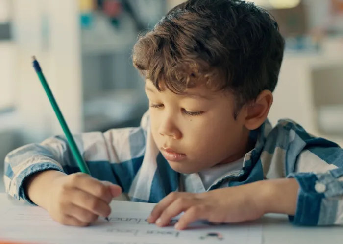 young boy putting his handwriting skills to work