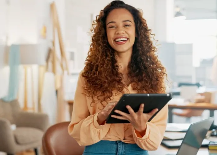 Technology, smile and online order with a young employee or small business owner in a workplace