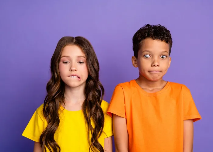 Photo of charming two little children nervous scared amazed wear trendy orange yellow outfit isolated on violet color background.